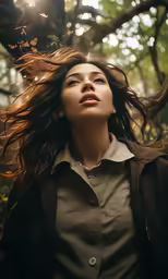 a young woman with long hair standing in the woods