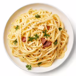 a white plate with spaghetti and garnished with fresh herbs