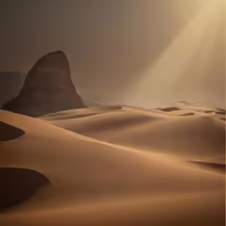 some sand hills with a hill in the distance
