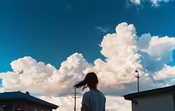 a girl looking up at the clouds that she is flying in