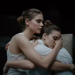 two women are hugging and one is sitting on her back