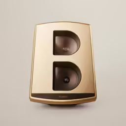 a gold and black speaker that is on top of a table