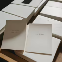 two cards on a table with paper for an envelope