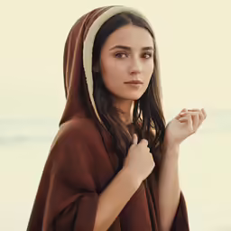 a young girl in a nun outfit standing by the ocean