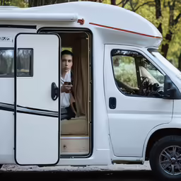 the driver is in his van looking out of the window