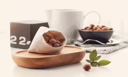 some nuts in a bag are sitting on a wooden tray
