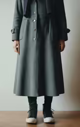 a person standing wearing a green coat