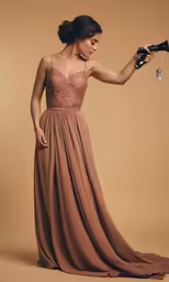 a woman in a brown long dress holding an object