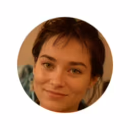a woman smiling in the camera with a button on her left ear,a round picture with the image of a smiling woman