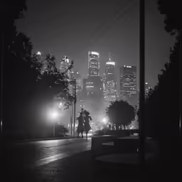 people walking in the rain along a street at night
