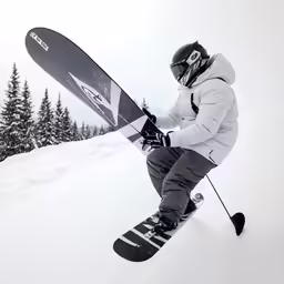 a man in grey jacket carrying a snow board