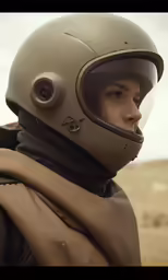 the person is wearing a helmet and looking off into the distance