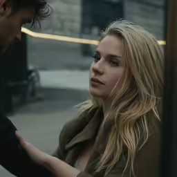 a beautiful blonde girl standing next to a man