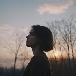 a person in profile while the sun is behind them