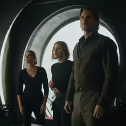a group of people standing around a large window
