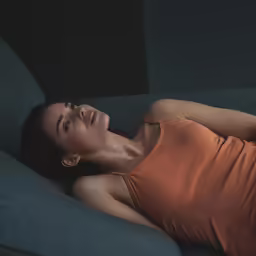 a young woman lying down on a couch