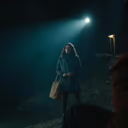 a person holding a bag in the dark