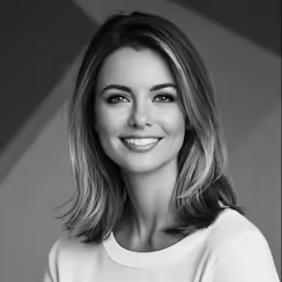 a woman smiling for the camera with a white shirt on