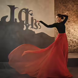 a woman is dressed in a long red and black dress