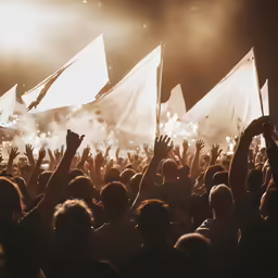 people raising their hands up while watching a musical performance