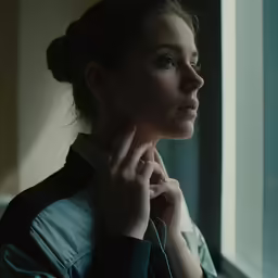 a girl looking out a window with the side view of her head