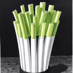 a white vase with green pens in it