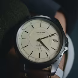 a man is holding his watch in his hand