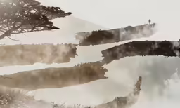 a mountain range with water reflecting and trees