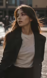 the woman is walking down the sidewalk wearing a black coat