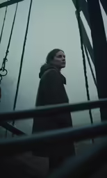 a woman standing near ropes in the fog