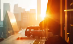 the sun peeking through a window of a car and city