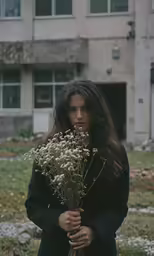 the woman has long hair and is holding flowers