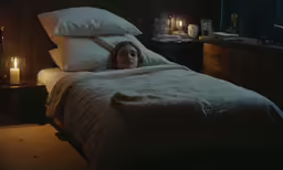 the young girl lies in bed alone among the pillows