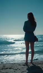 a woman is looking out at the ocean