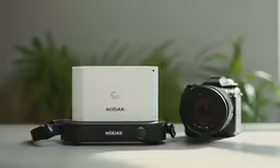 a camera, and its lens with the box sitting on it