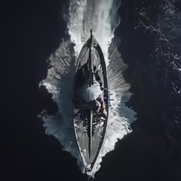 a large boat with a man sitting on it going across the water