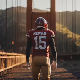 a football player walking on the road with the golden gate bridge in the background