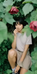 a young asian woman sits on a branch with flowers in the background