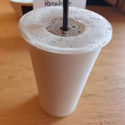 the table has been turned into a plastic cup with an umbrella inside