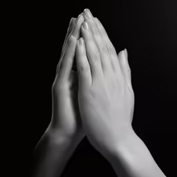 two hands in pray position with black background