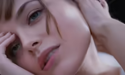a woman with light blue eyes has her hand over her head