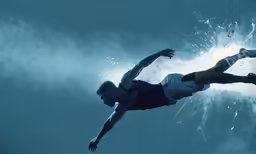 a man riding on top of a skateboard under water