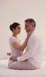 a man sitting on the bed and cuddling his wife