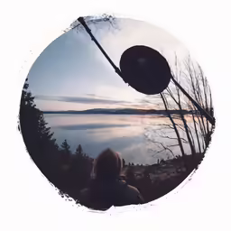 the person in the jacket is looking out at the lake