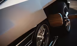 a white sports car with wooden stripe side trim