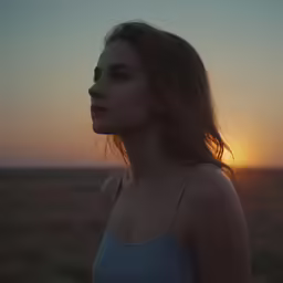 an attractive young lady standing in a field