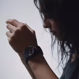 a woman with her arm on the wrist of her watch