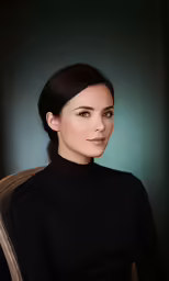 a woman wearing black dress sitting in a chair
