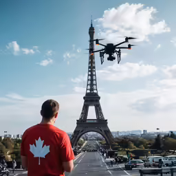 a person watches as a djoope prepares to land on top of the eiffel tower