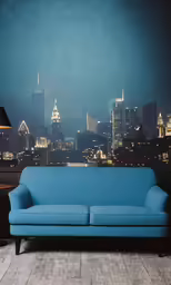 a couch on a wooden floor with a blue wall behind it
